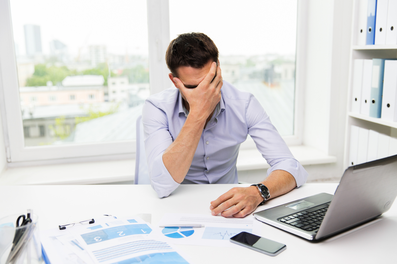 An exhausted employee reflecting at a desk during a demanding workday.