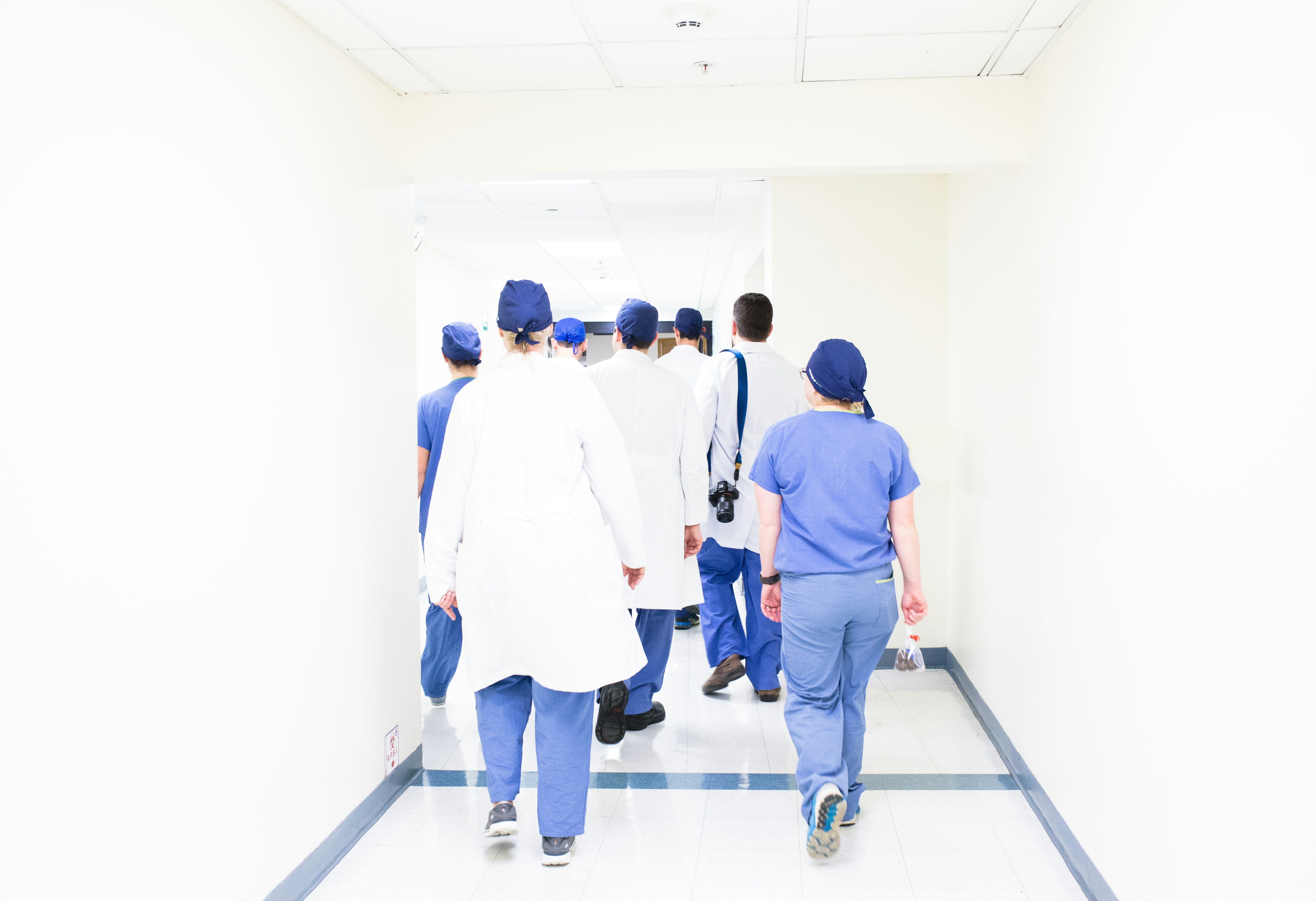 A group of doctors coordinating care in a hospital hallway.
