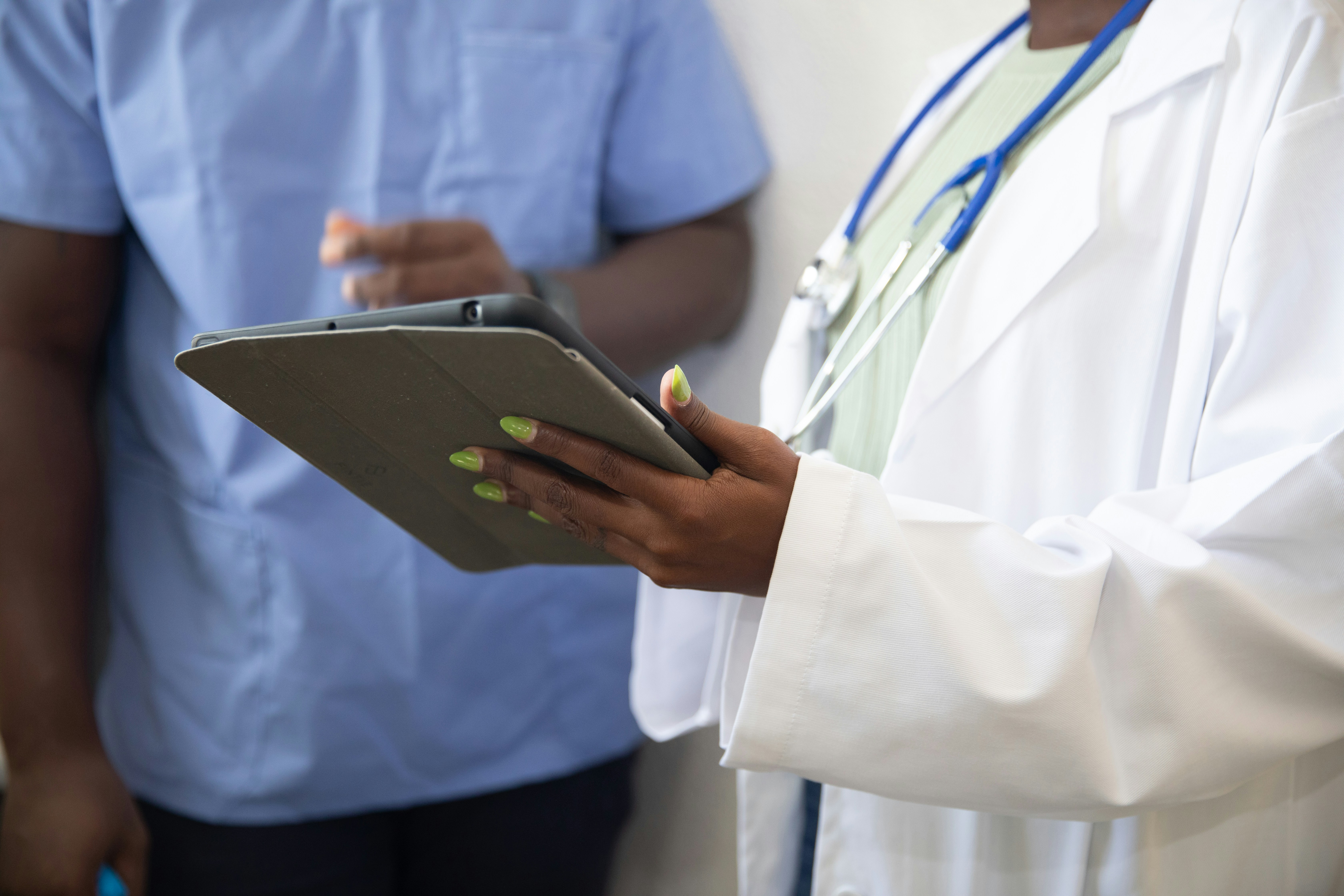 A doctor reviewing a patient care plan with a patient on a tablet.