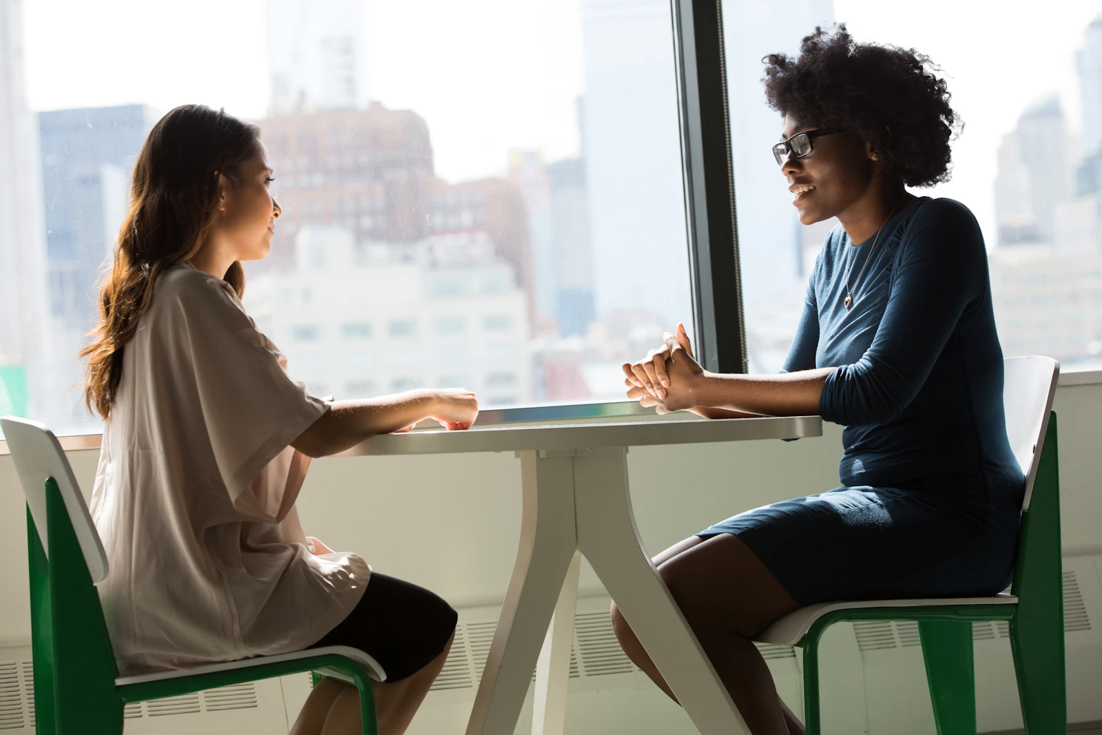 Two colleagues in a candid one on one conversation at work.