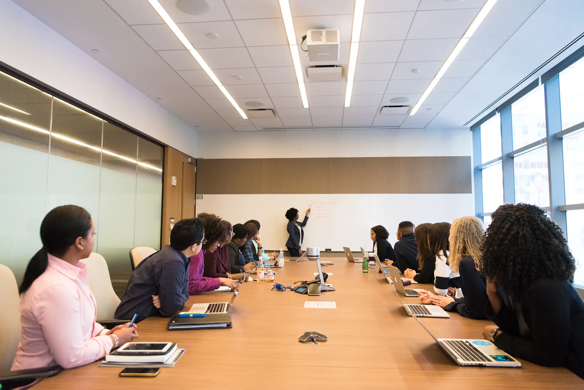 A leader addressing a small team around a conference table in a modern office.